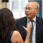 Man speaks to woman at event.
